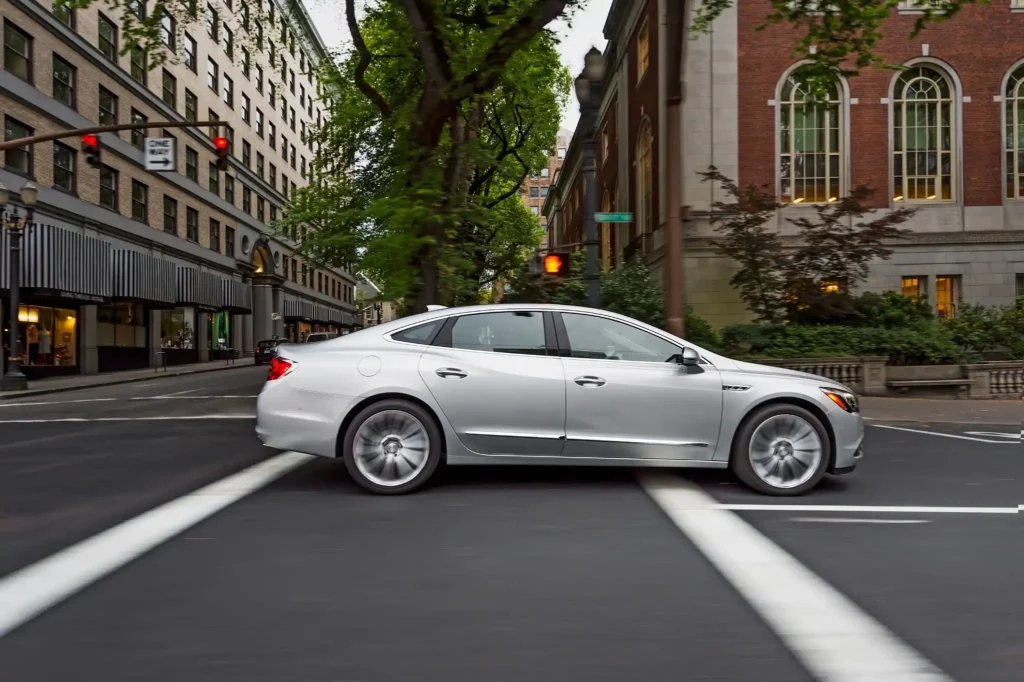2017 Buick LaCrosse silver sedan driving through city intersection luxury midsize car in motion 2017 Buick LaCrosse silver sedan driving through city intersection luxury midsize car in motion