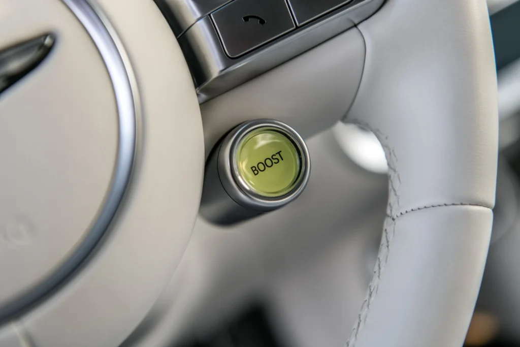 Close up of Genesis GV60 steering wheel Boost mode button for enhanced performance Close up of Genesis GV60 steering wheel Boost mode button for enhanced performance