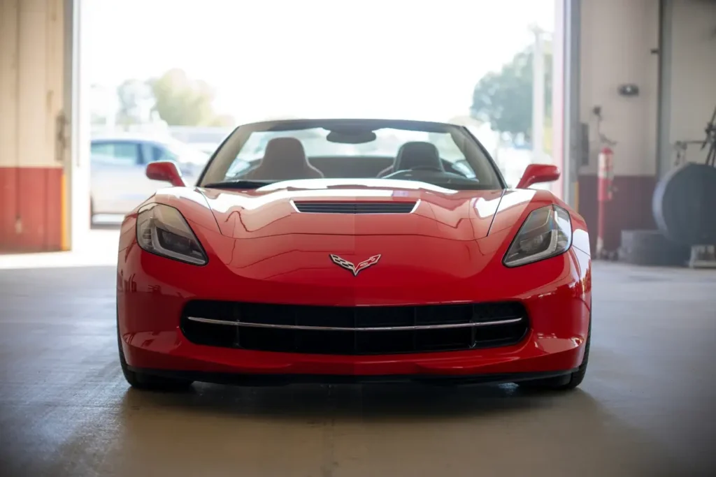 2014 Corvette Stingray Z51 Convertible in red front view indoors sharp LED headlights aggressive grille low slung sports car 2014 Corvette Stingray Z51 Convertible in red front view indoors sharp LED headlights aggressive grille low slung sports car