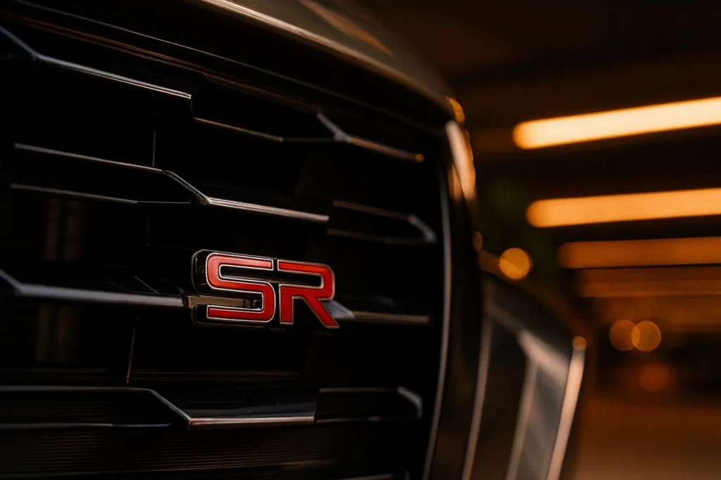 2025 Nissan Altima SR front close up in parking garage red SR grille badge against black V Motion mesh 2025 Nissan Altima SR front close up in parking garage red SR grille badge against black V Motion mesh