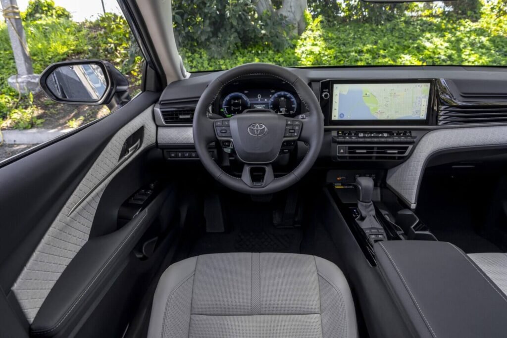 2025 Toyota Camry driver cockpit interior showing digital gauge cluster multifunction steering wheel widescreen infotainment display and refined dashboard design emphasizing modern technology and comfort 2025 Toyota Camry driver cockpit interior showing digital gauge cluster multifunction steering wheel widescreen infotainment display and refined dashboard design emphasizing modern technology and comfort