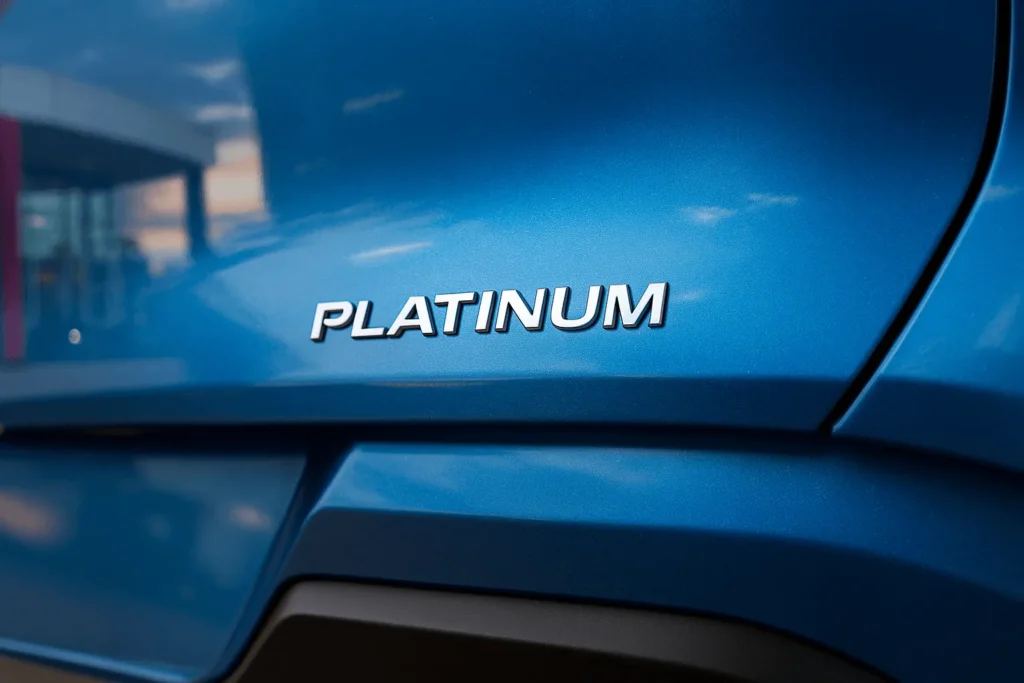 Close up rear view of 2025 Nissan Murano Platinum tailgate focusing on Platinum badge against sculpted blue crossover bodywork Close up rear view of 2025 Nissan Murano Platinum tailgate focusing on Platinum badge against sculpted blue crossover bodywork