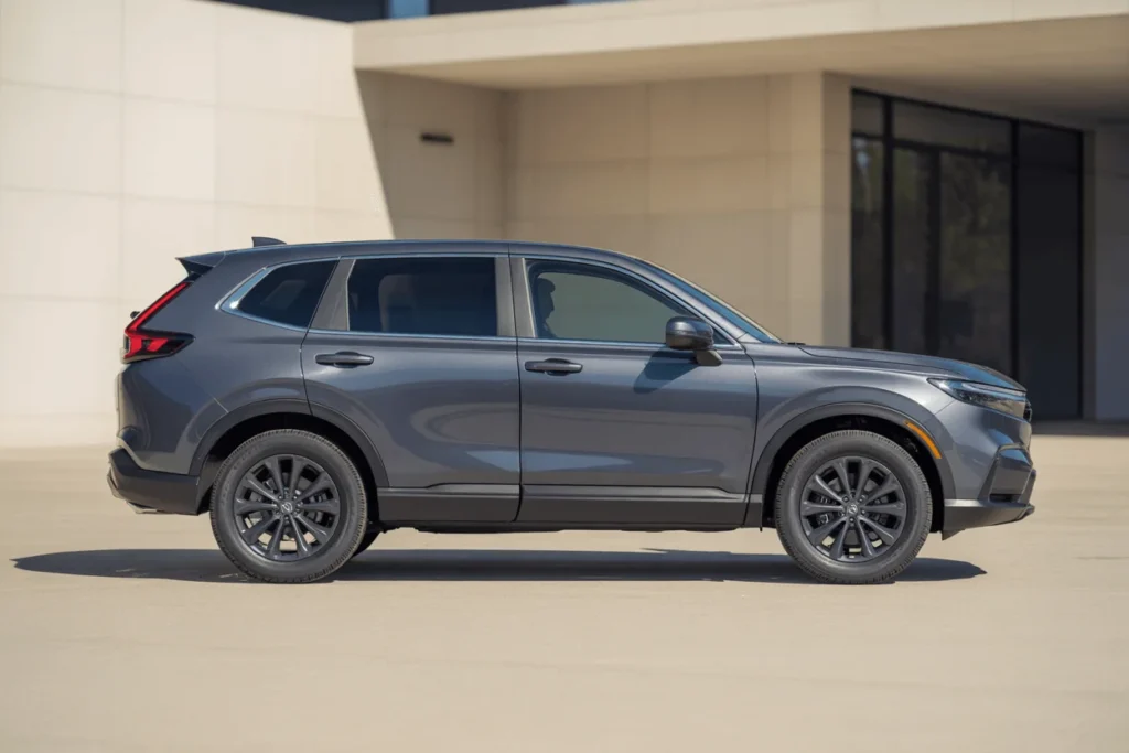 Full side profile of 2025 Honda CR V SUV on bright pavement showcasing roofline window design and dark alloy wheels Full side profile of 2025 Honda CR V SUV on bright pavement showcasing roofline window design and dark alloy wheels