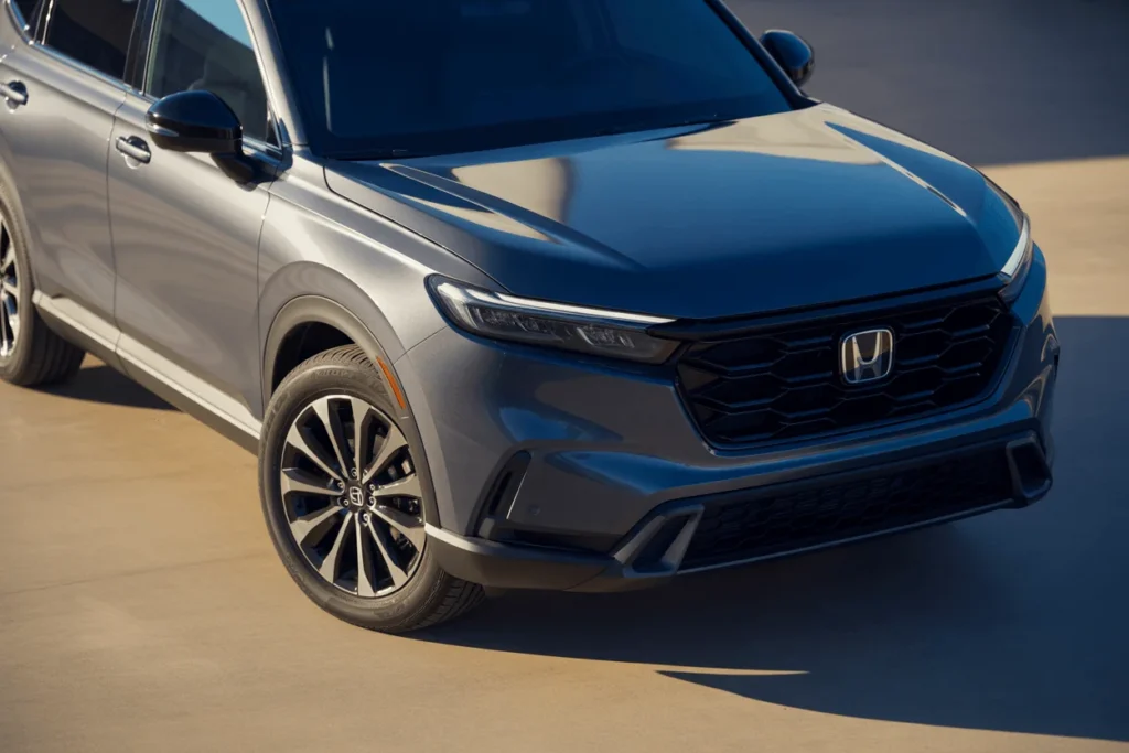 High front three quarter angle of 2025 Honda CR V focusing on hood reflections grille texture and stylish alloy wheels High front three quarter angle of 2025 Honda CR V focusing on hood reflections grille texture and stylish alloy wheels