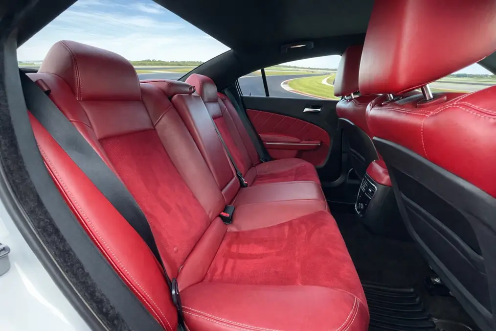 2014 Dodge Charger SRT8 Super Bee rear seat side view with red suede inserts on racetrack 2014 Dodge Charger SRT8 Super Bee rear seat side view with red suede inserts on racetrack