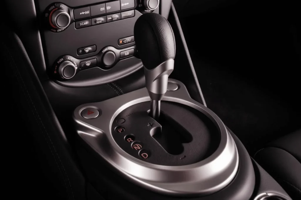 2014 Nissan 370Z Nismo automatic transmission closeup silver surround leather shift knob visible gear positions dark console 2014 Nissan 370Z Nismo automatic transmission closeup silver surround leather shift knob visible gear positions dark console