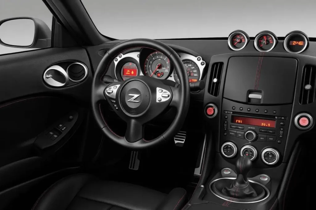 2014 Nissan 370Z Nismo driver cockpit view three gauge dashboard analog speedometer leather steering wheel manual gear shifter 2014 Nissan 370Z Nismo driver cockpit view three gauge dashboard analog speedometer leather steering wheel manual gear shifter