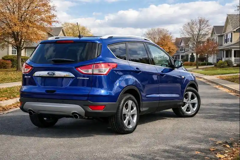 2016 Ford Escape Titanium rear three quarter driver side view showing alloy wheels roof rails Deep Impact Blue paint on suburban street 2016 Ford Escape Titanium rear three quarter driver side view showing alloy wheels roof rails Deep Impact Blue paint on suburban street