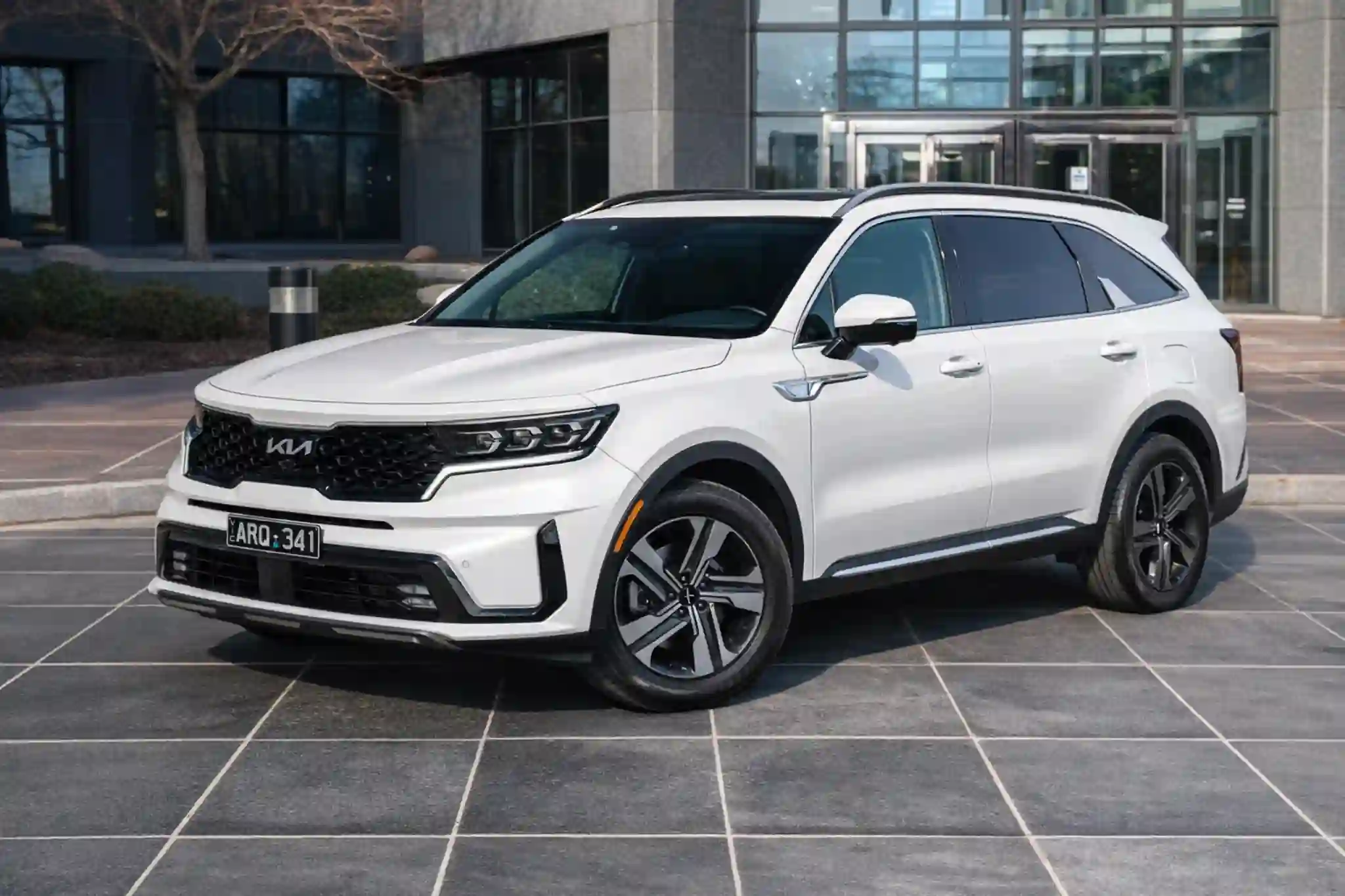 Front three-quarter view of 2022 Kia Sorento X-Line SX Prestige on plaza, black honeycomb grille, LED headlights.