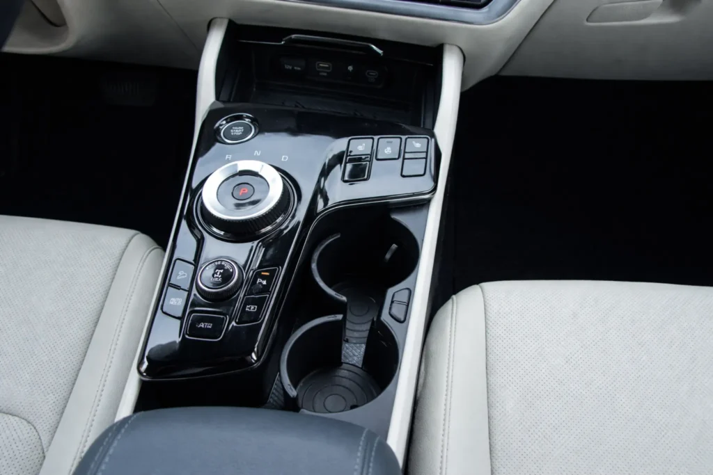 2023 Kia Sportage Plug in Hybrid center console overhead view with rotary dial shifter cupholders and control buttons 2023 Kia Sportage Plug in Hybrid center console overhead view with rotary dial shifter cupholders and control buttons