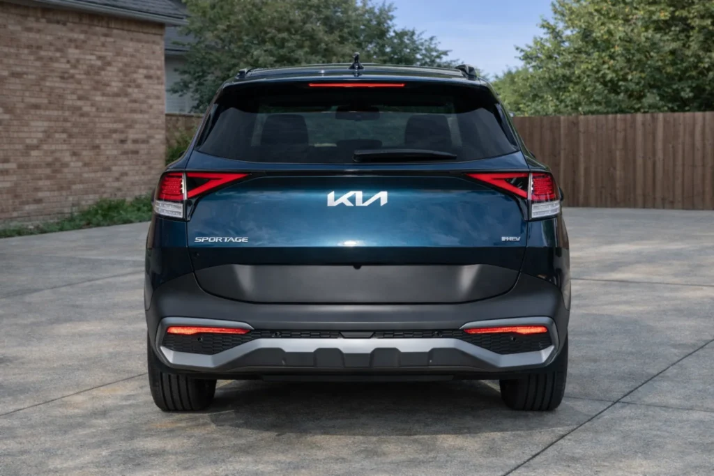 2023 Kia Sportage Plug in Hybrid centered rear view on driveway with Kia emblem and PHEV badge 2023 Kia Sportage Plug in Hybrid centered rear view on driveway with Kia emblem and PHEV badge
