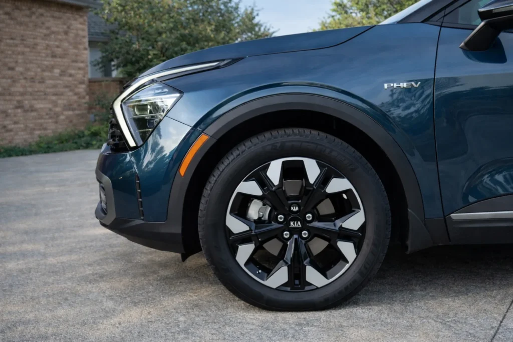 2023 Kia Sportage Plug in Hybrid driver side front wheel close up on driveway with PHEV badge 2023 Kia Sportage Plug in Hybrid driver side front wheel close up on driveway with PHEV badge
