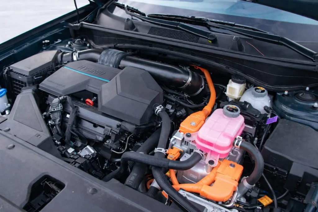 2023 Kia Sportage Plug in Hybrid engine bay top view showing orange high voltage cables and coolant reservoir 2023 Kia Sportage Plug in Hybrid engine bay top view showing orange high voltage cables and coolant reservoir