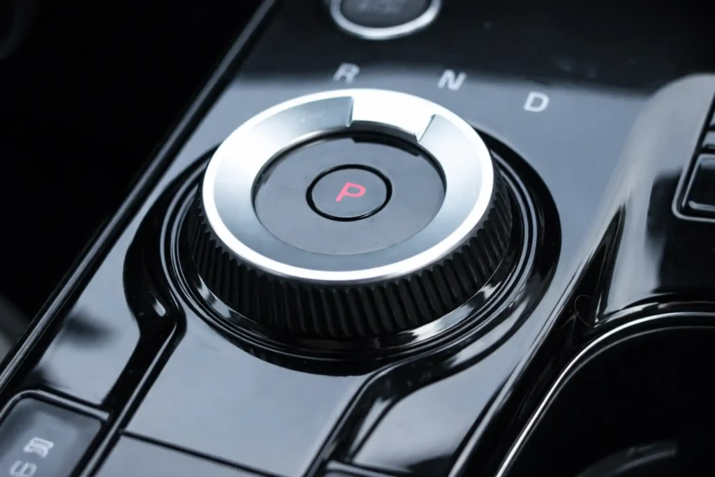 2023 Kia Sportage Plug in Hybrid rotary shifter close up from above with Park button and PRND markings 2023 Kia Sportage Plug in Hybrid rotary shifter close up from above with Park button and PRND markings