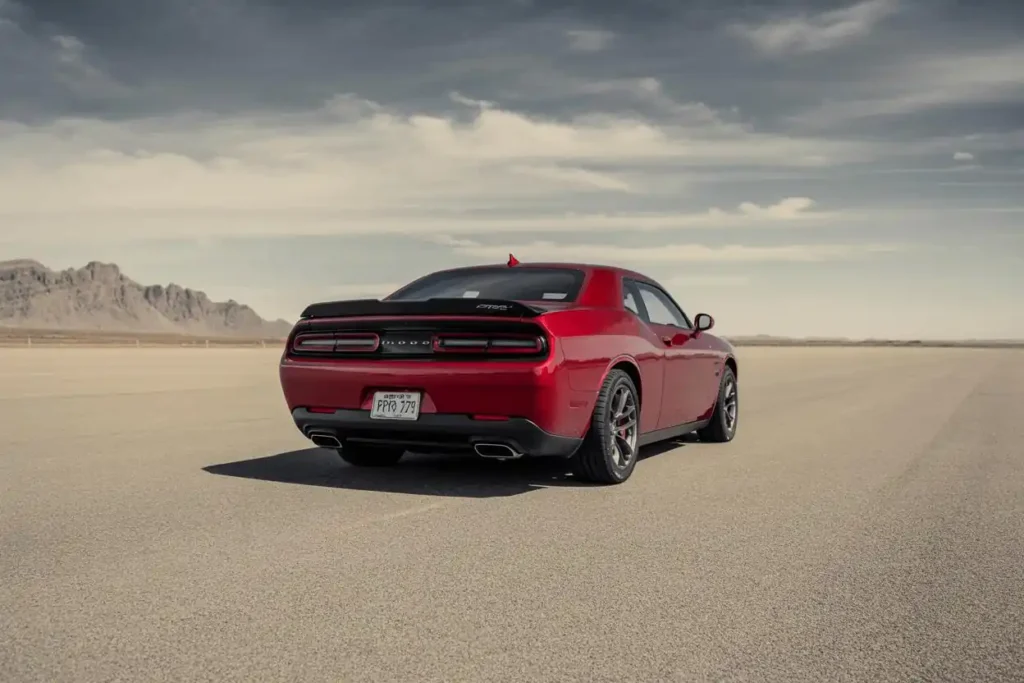 Angled rear view of 2015 Dodge Challenger SRT 392 sports coupe in deep red mountain backdrop and black alloy wheels Angled rear view of 2015 Dodge Challenger SRT 392 sports coupe in deep red mountain backdrop and black alloy wheels