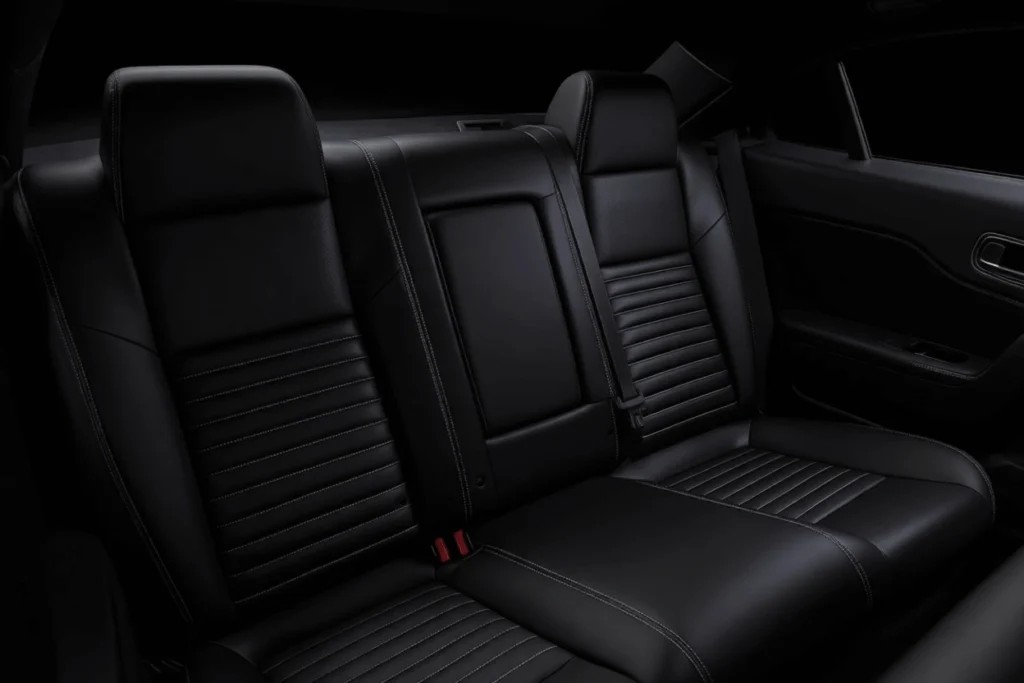 Rear seat interior view of 2013 Dodge Challenger RT Plus in dark cabin black leather bench headrests and contrast stitching Rear seat interior view of 2013 Dodge Challenger RT Plus in dark cabin black leather bench headrests and contrast stitching