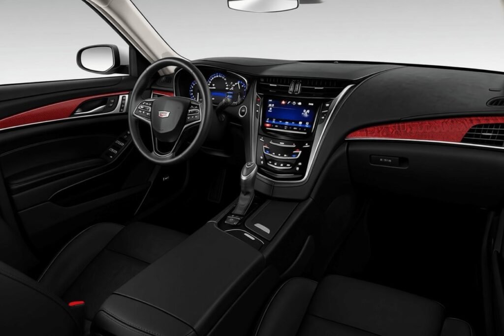 Wide front interior view of 2016 Cadillac CTS black leather seats red wood trim and CUE infotainment display Wide front interior view of 2016 Cadillac CTS black leather seats red wood trim and CUE infotainment display